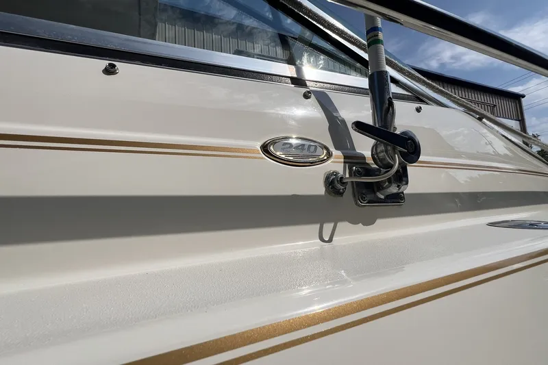 Slide: The Image of Close-up of a 1997 Sea Ray 240 Overnighter boat exterior with gold trim. - 72