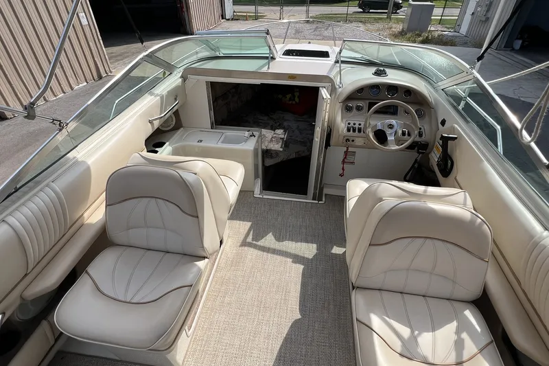 Slide: The Image of 1997 Sea Ray 240 Overnighter boat interior with beige seating and steering console. - 41