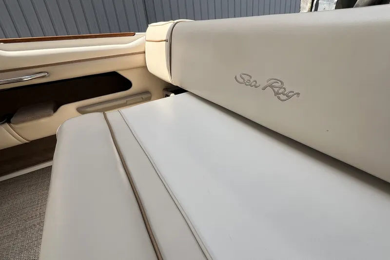 Slide: The Image of 1997 Sea Ray 240 Overnighter boat interior with beige upholstery and logo. - 94