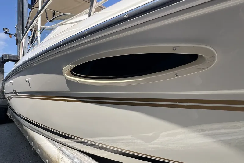Slide: The Image of 1997 Sea Ray 240 Overnighter boat side view with sleek design and porthole. - 74