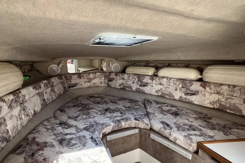 Slide: The Image of 1997 Sea Ray 240 Overnighter cabin interior with patterned upholstery and overhead hatch. - 46