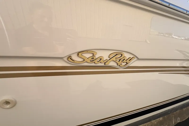 Slide: The Image of 1997 Sea Ray 240 Overnighter boat with gold logo and sleek design. - 80
