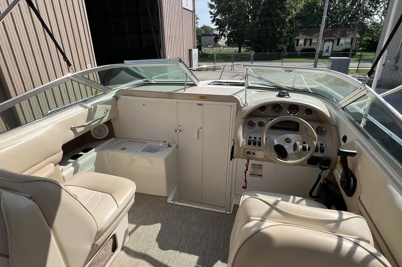 Slide: The Image of 1997 Sea Ray 240 Overnighter boat interior with beige seating and control panel. - 65