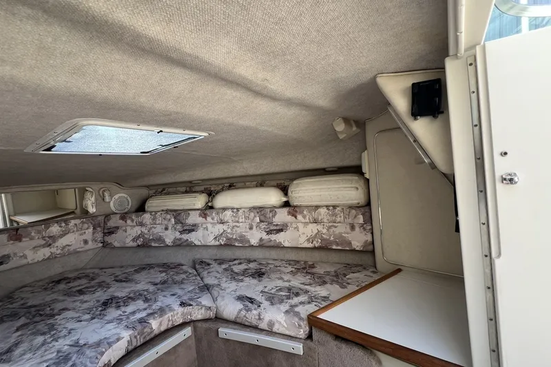 Slide: The Image of Interior cabin of a 1997 Sea Ray 240 Overnighter boat, featuring cushioned seating. - 61