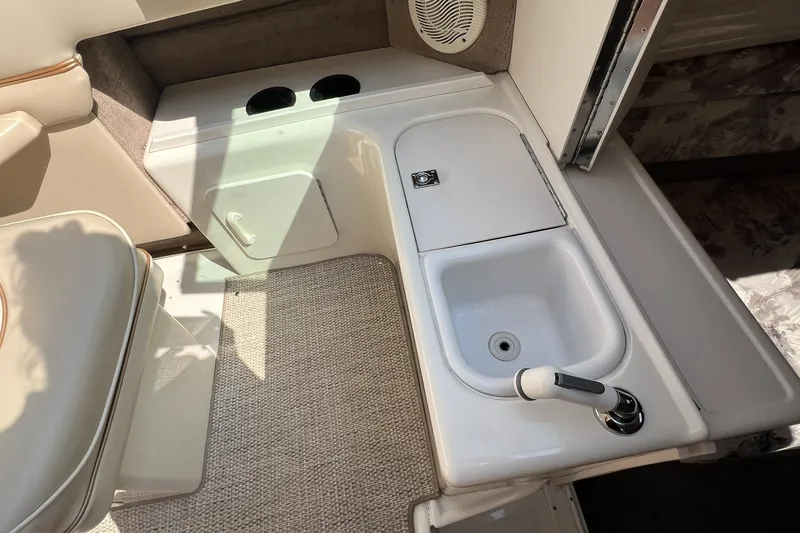 Slide: The Image of Interior of a 1997 Sea Ray 240 Overnighter boat featuring a compact sink and seating area. - 63