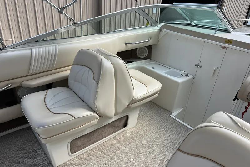 Slide: The Image of 1997 Sea Ray 240 Overnighter boat interior with white seating and dashboard. - 19