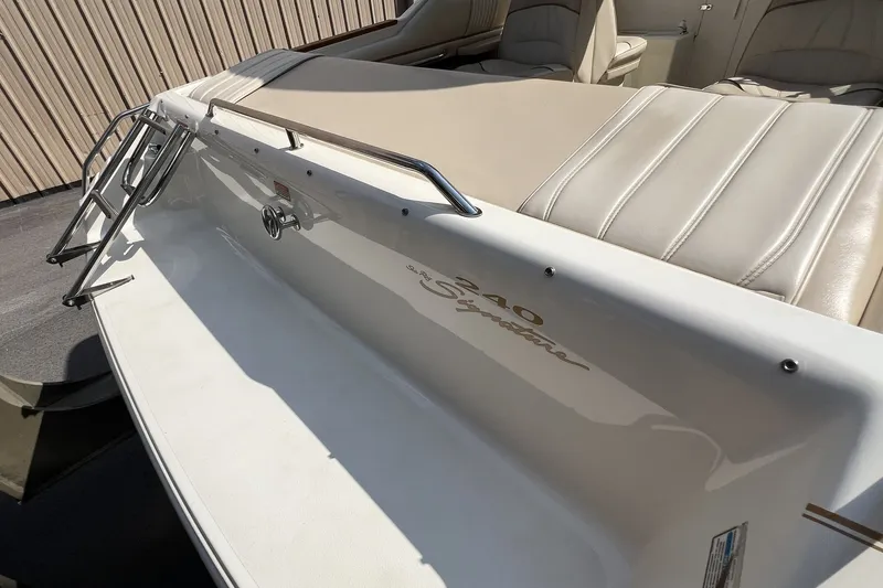 Slide: The Image of 1997 Sea Ray 240 Overnighter boat with beige seating and stainless steel ladder. - 67