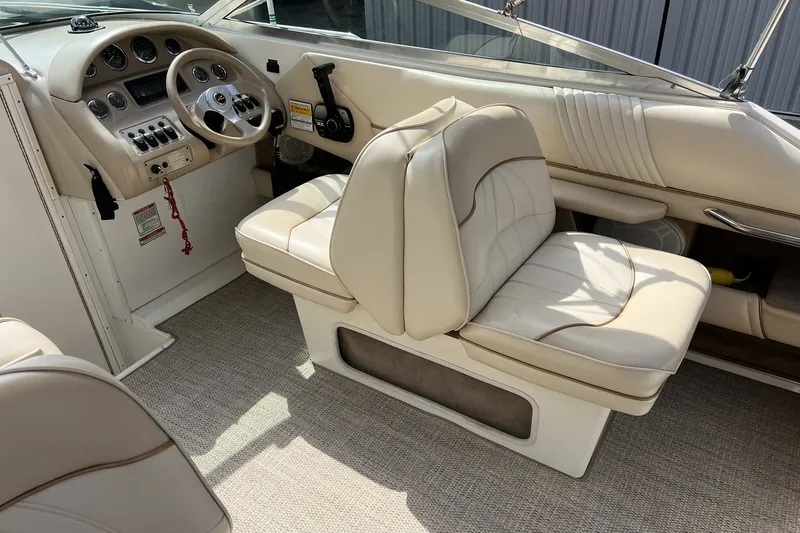 Slide: The Image of 1997 Sea Ray 240 Overnighter boat interior with beige seating and control panel. - 18
