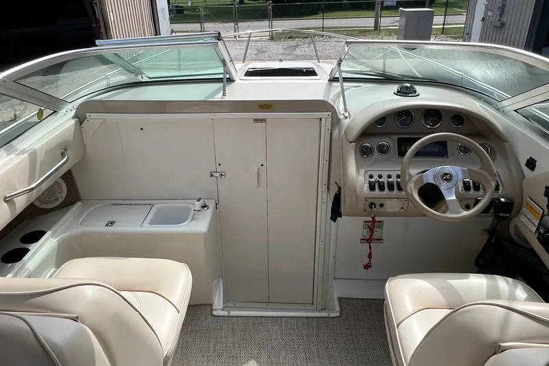 Slide: The Image of 1997 Sea Ray 240 Overnighter boat interior with steering wheel and dashboard controls. - 28