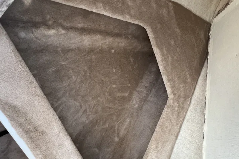 Slide: The Image of Interior cabin of a 1997 Sea Ray 240 Overnighter boat, featuring beige upholstery. - 58