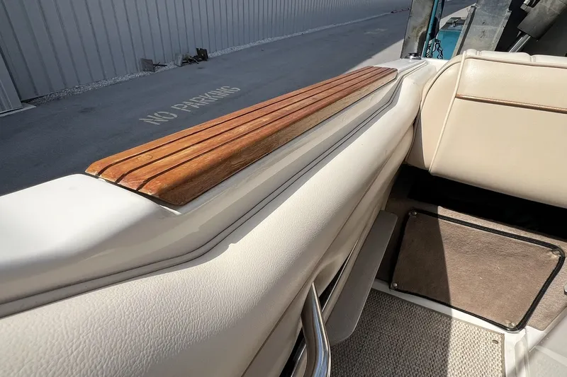 Slide: The Image of Interior of a 1997 Sea Ray 240 Overnighter boat with wood trim and beige seating. - 93