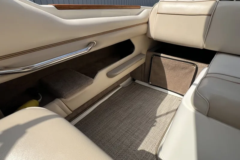 Slide: The Image of 1997 Sea Ray 240 Overnighter interior with beige seating and carpeted flooring. - 91