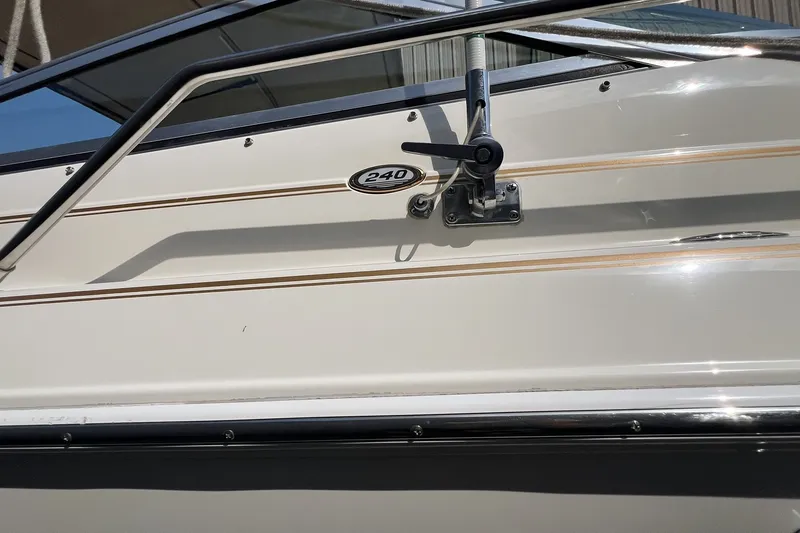 Slide: The Image of 1997 Sea Ray 240 Overnighter boat side view with railing and model emblem. - 73