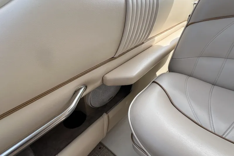 Slide: The Image of Interior of a 1997 Sea Ray 240 Overnighter boat, featuring beige seating and speaker. - 30