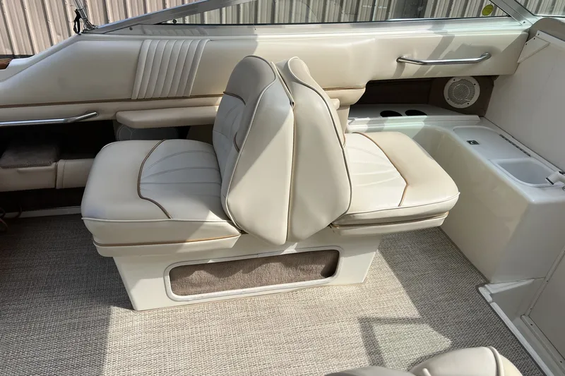 Slide: The Image of 1997 Sea Ray 240 Overnighter interior with beige seating and carpeted flooring. - 21