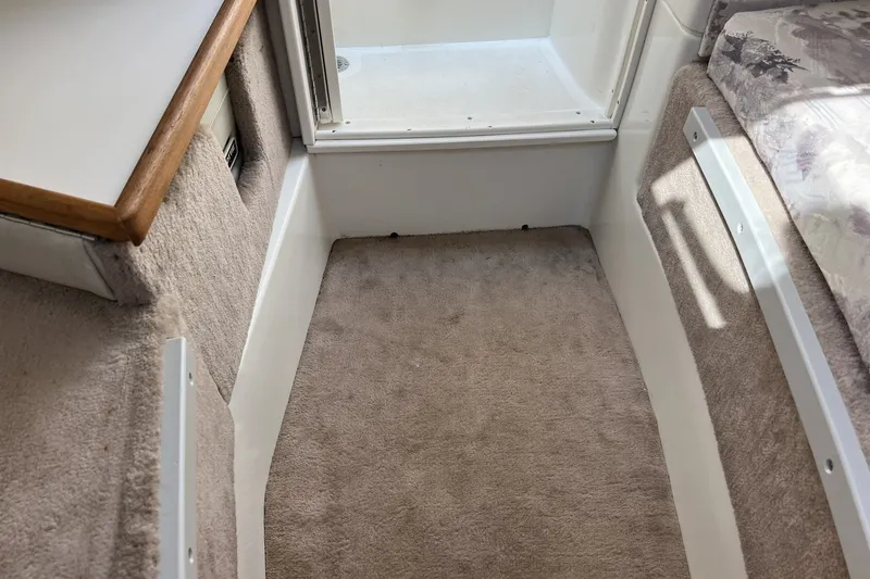 Slide: The Image of Interior cabin of a 1997 Sea Ray 240 Overnighter boat with carpeted flooring. - 47