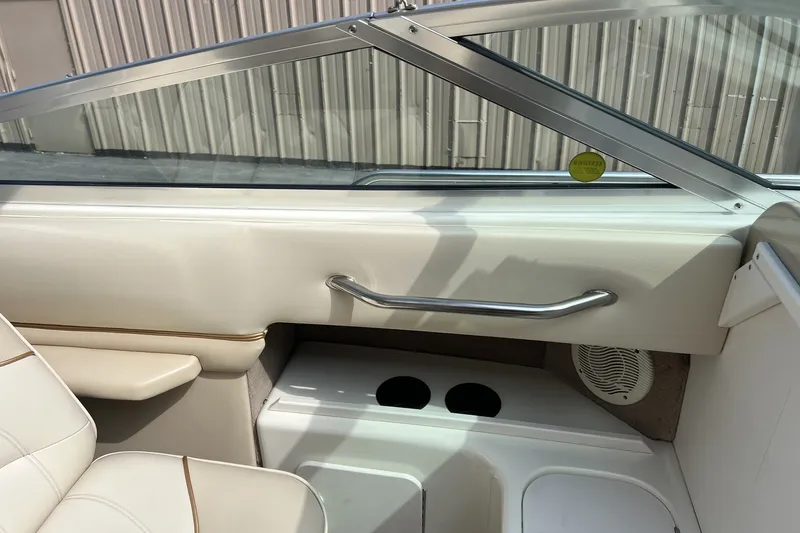 Slide: The Image of Interior view of a 1997 Sea Ray 240 Overnighter boat, featuring seating and cup holders. - 25