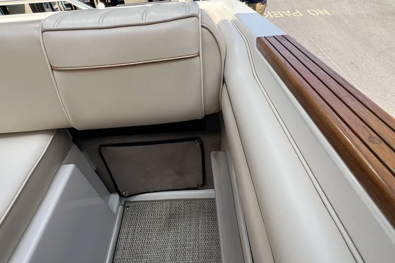 Slide: The Image of Interior view of a 1997 Sea Ray 240 Overnighter boat with cushioned seating and wooden trim. - 95