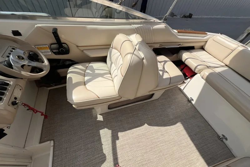 Slide: The Image of 1997 Sea Ray 240 Overnighter interior with beige seating and steering wheel. - 37