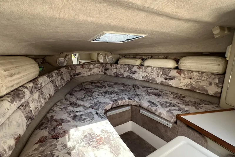 Slide: The Image of 1997 Sea Ray 240 Overnighter cabin interior with patterned upholstery and compact design. - 60