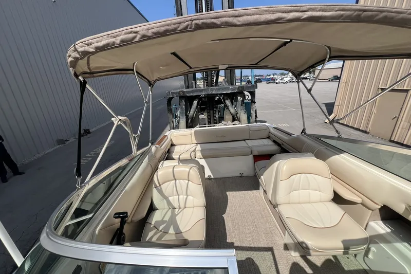 Slide: The Image of 1997 Sea Ray 240 Overnighter boat interior with beige seating and canopy. - 35