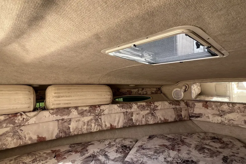 Slide: The Image of 1997 Sea Ray 240 Overnighter cabin interior with patterned upholstery and overhead hatch. - 53