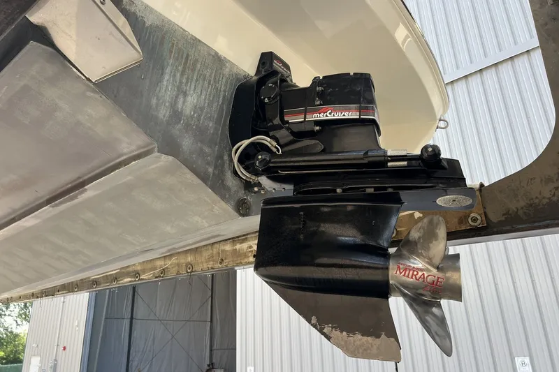 Slide: The Image of 1997 Sea Ray 240 Overnighter boat with MerCruiser outdrive and Mirage propeller in a storage facility. - 90