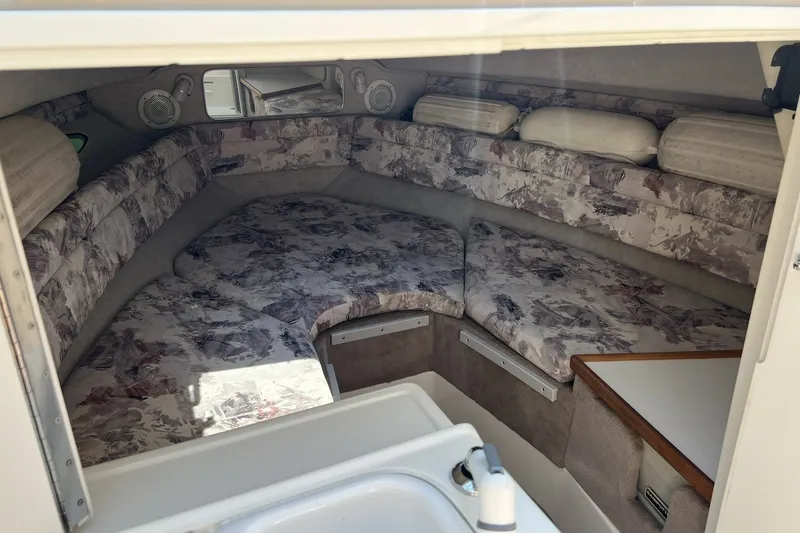 Slide: The Image of 1997 Sea Ray 240 Overnighter cabin interior with patterned cushions and compact sink. - 44