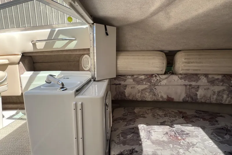Slide: The Image of 1997 Sea Ray 240 Overnighter cabin interior with sink and seating area. - 52