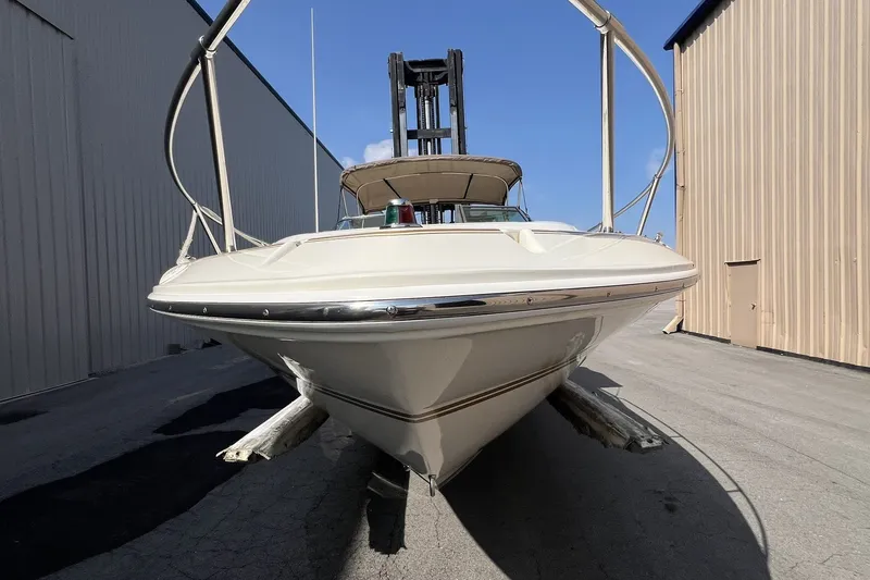 Slide: The Image of 1997 Sea Ray 240 Overnighter boat on dry dock between buildings, front view. - 77
