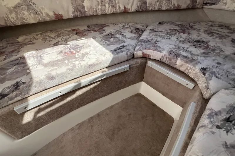 Slide: The Image of 1997 Sea Ray 240 Overnighter cabin interior with patterned upholstery and carpeted flooring. - 57