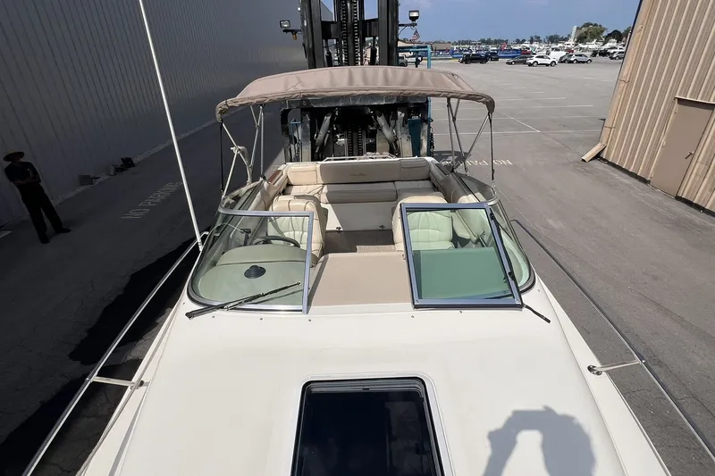 Slide: The Image of 1997 Sea Ray 240 Overnighter boat with open cockpit and canopy in a marina. - 34