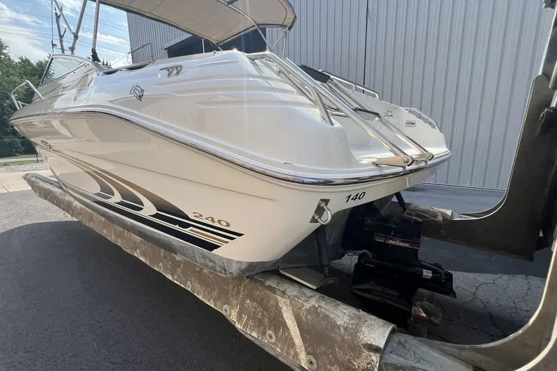 Slide: The Image of 1997 Sea Ray 240 Overnighter boat on a trailer, parked outdoors. - 83