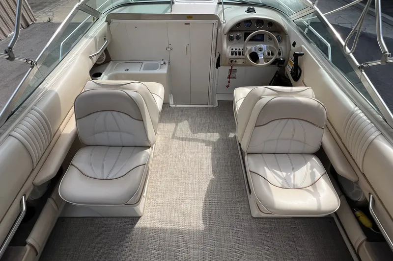 Slide: The Image of 1997 Sea Ray 240 Overnighter boat interior with beige seating and steering console. - 29