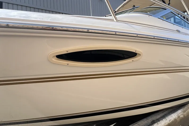 Slide: The Image of 1997 Sea Ray 240 Overnighter boat side view with oval window detail. - 79