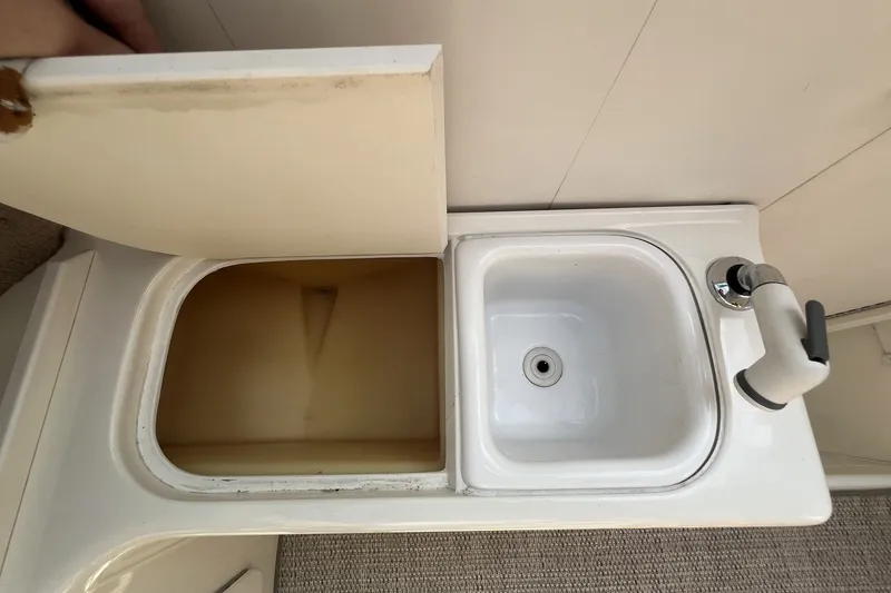 Slide: The Image of 1997 Sea Ray 240 Overnighter boat sink and storage compartment. - 40