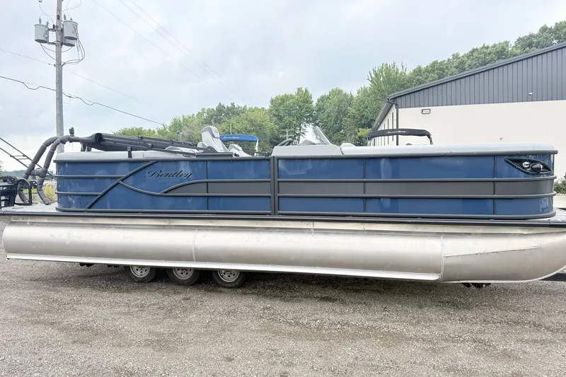 The Image of 2027 Bentley Pontoons Legacy 243 DL Navigator, blue pontoon boat, parked outdoors. - 0