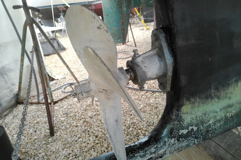 Slide: The Image of Propeller of a 2005 Mariner 34 Orient boat on dry dock, surrounded by gravel. - 7