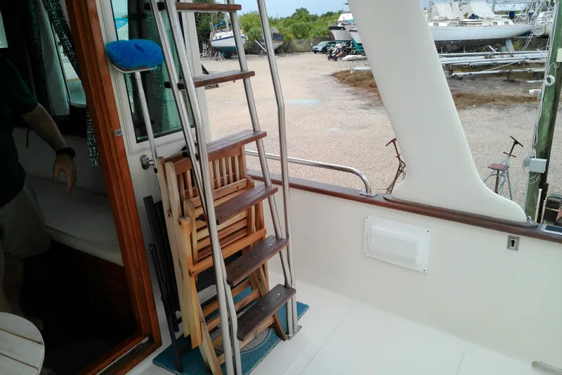 Slide: The Image of 2005 Mariner 34 Orient boat interior with ladder and wooden chairs on deck. - 18