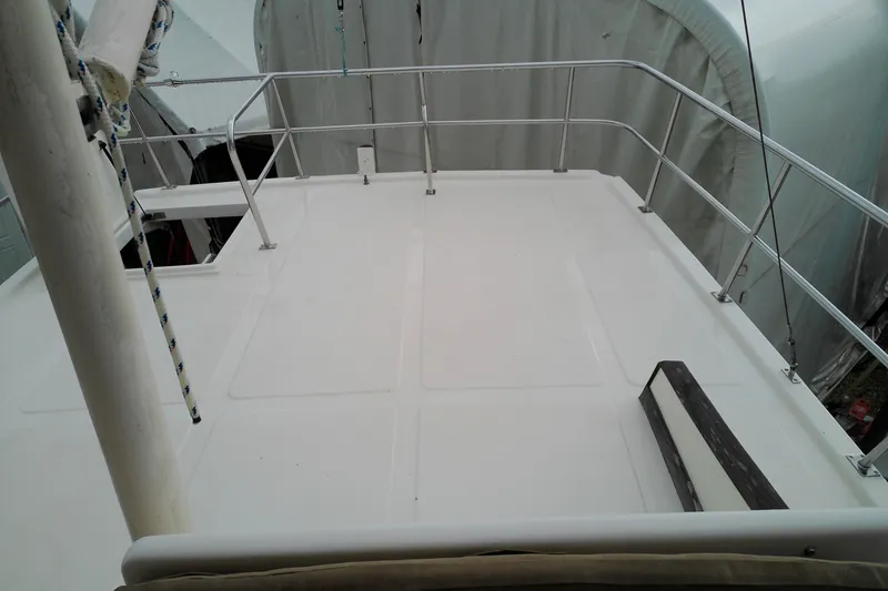 Slide: The Image of Deck of a 2005 Mariner 34 Orient boat, featuring clean white surface and railing. - 43