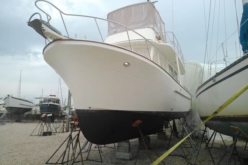 Slide: The Image of 2005 Mariner 34 Orient yacht on stands in a boatyard, surrounded by other vessels. - 4