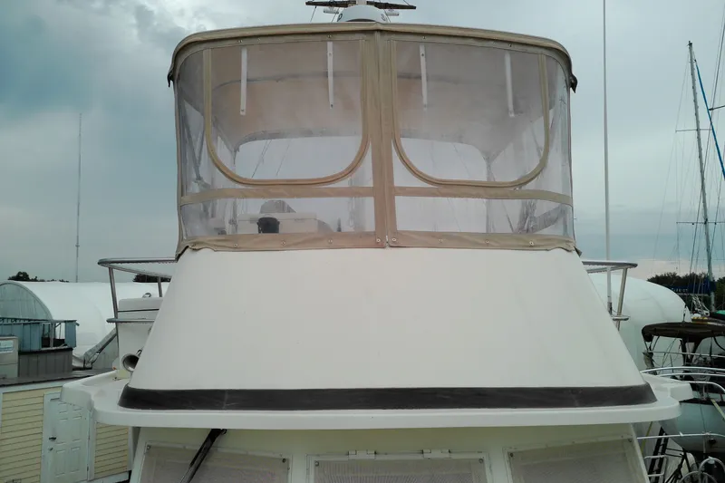 Slide: The Image of 2005 Mariner 34 Orient boat with enclosed flybridge, docked at marina. - 14