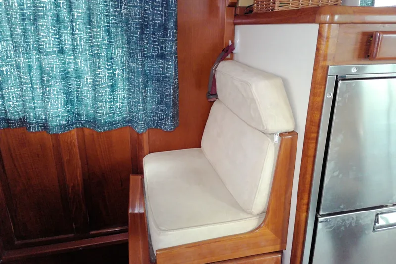 Slide: The Image of Cozy seating area in 2005 Mariner 34 Orient yacht interior with blue curtains. - 24
