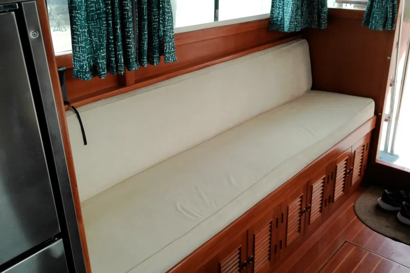 Slide: The Image of Interior of 2005 Mariner 34 Orient boat with cushioned seating and wooden storage. - 27