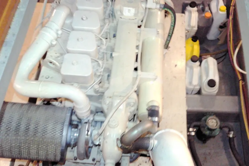 Slide: The Image of Engine compartment of a 2005 Mariner 34 Orient boat, showcasing mechanical components and fluid containers. - 34