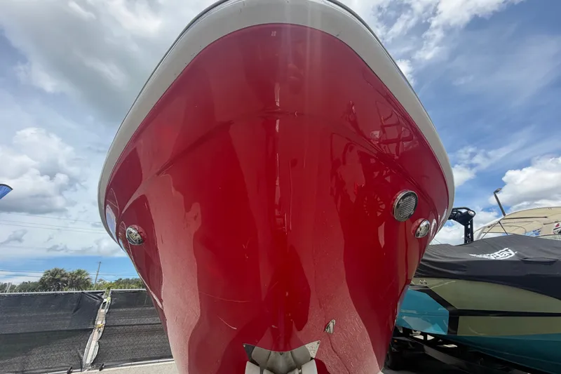 Slide: The Image of Red 2016 Glastron GT 245 boat under a partly cloudy sky. - 4