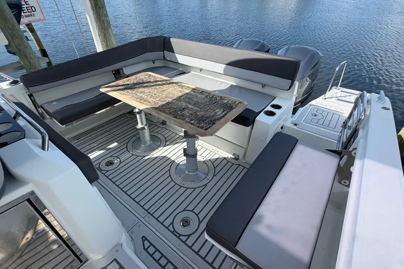 Slide: The Image of 2021 Jeanneau Cap Camarat 9.0 WA boat interior with seating and table, docked by water. - 24