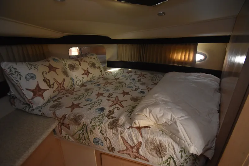 Slide: The Image of The image shows a cozy cabin with a bed adorned with a nautical-themed bedspread. - 11