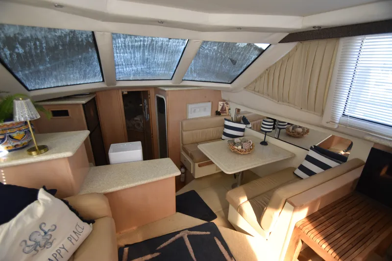 Slide: The Image of Interior of the 2000 Carver 356 Aft Cabin Motor Yacht with cozy seating area and dining table. - 7