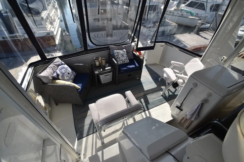 Slide: The Image of The 2000 Carver 356 Aft Cabin Motor Yacht features a cozy seating area with cushions and a rug. - 5